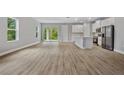 Bright, open-concept living room featuring modern floors that connect to a stylish kitchen and backyard access at 2643 Rushmore St, North Port, FL 34288