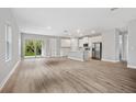Open-concept living area flowing into a modern kitchen with stainless steel appliances and sliding glass door to the yard at 2643 Rushmore St, North Port, FL 34288
