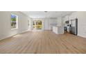 Bright open-concept living room with hardwood floors, natural light, and sliding glass doors to the outdoor area at 3779 Clearfield St, North Port, FL 34286