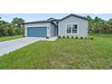 Newly built home with a gray exterior and a two-car garage at 3883 Dominic St, North Port, FL 34288