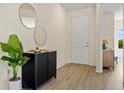 Inviting entryway featuring modern decor, stylish cabinet, round mirrors, and durable flooring at 4131 Bula Ln, North Port, FL 34287