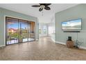 Bright living room with tiled floors, balcony access, and a ceiling fan at 95 Vivante Blvd # 9534, Punta Gorda, FL 33950