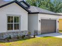 Lovely single-Gathering home featuring neutral siding, a gray roof, and a spacious garage at 1100 S Wapello St, North Port, FL 34286