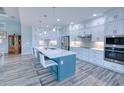 Modern kitchen with white cabinets, quartz countertops and teal island at 1450 Kiwi Ct, Punta Gorda, FL 33950