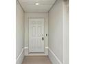 This is an entryway showcasing a white door with six panels and a textured wall, creating a simple, clean aesthetic at 16307 Alcira Cir, Punta Gorda, FL 33955