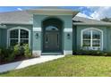 Charming home featuring a covered front entrance, arched windows, and meticulously maintained landscaping at 27462 Pasto Dr, Punta Gorda, FL 33983