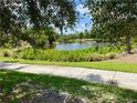 Landscaped walking path alongside a peaceful community lake at 5101 Pine Shadow Ln, North Port, FL 34287