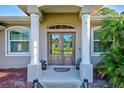 Double front doors with sidelights, columns, and a mat at 5644 Cissus Ave, North Port, FL 34288
