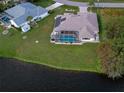 Aerial view of a home with a private pool and a lush green backyard near a lake at 198 Coblentz St, Port Charlotte, FL 33954