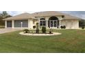 House exterior showcasing a two-car garage and well-maintained landscaping at 198 Coblentz St, Port Charlotte, FL 33954