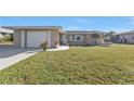 Charming single-story home with a well-manicured lawn and attached garage at 201 W Tarpon Nw Blvd, Port Charlotte, FL 33952