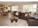 Open living room with leather sofas, tiled floors, and a view into the dining area at 2620 Tarpon Cove Dr # 311, Punta Gorda, FL 33950