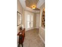 Bright entryway with tile flooring, wood accent table, and double French doors at 2620 Tarpon Cove Dr # 311, Punta Gorda, FL 33950