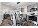 Open concept dining area with glass table and gray chairs, adjacent to kitchen at 6450 Floral Ct, North Port, FL 34287