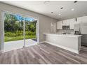 Open kitchen features island, stainless steel appliances, and sliding glass door to backyard at 1430 Nora Ln, North Port, FL 34286