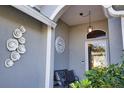 Front porch with a bench, clock, and decorative wall art at 5255 Drew Rd, Venice, FL 34293