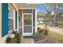 Front entrance with teal shutters and a screened porch at 1162 Green Oak Trl, Port Charlotte, FL 33948