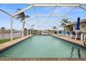 Inviting, screened-in pool with patio furniture and water views at 1230 Swan Ct, Punta Gorda, FL 33950