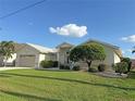 Tan house with two-car garage and nicely landscaped lawn at 1375 Grebe Dr, Punta Gorda, FL 33950