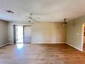 Open living room features wood-look flooring and sliding glass doors to outdoor area at 25068 Harborview Rd # 1A, Punta Gorda, FL 33980