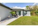 House exterior showcasing walkway, teal door, and landscaping at 4340 Adolph Ave, North Port, FL 34288