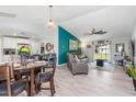 Open living area features gray couch, wood-look floors, and a view of the kitchen and backyard at 4340 Adolph Ave, North Port, FL 34288