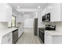 Modern white kitchen with stainless steel appliances and white cabinets at 1239 Ramsdel St, Port Charlotte, FL 33952