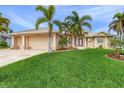 Two-story house with a two-car garage, palm trees, and lush lawn at 15460 Longview Rd, Port Charlotte, FL 33981