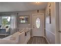 Bright entryway with wood-look floors, white door, and cozy seating area at 26352 Copiapo Cir, Punta Gorda, FL 33983