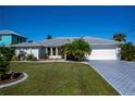 Single story home with paver driveway and tropical landscaping at 12102 Chancellor Blvd, Port Charlotte, FL 33953