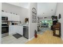 Kitchen with white cabinets, stainless steel appliances and view to living room at 19310 Water Oak Dr # 203, Port Charlotte, FL 33948