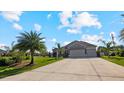 Two-story house with three-car garage and lush landscaping at 2705 Lamkin Rd, North Port, FL 34288