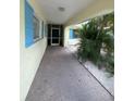 View of a walkway with blue shuttered windows and bright yellow exterior at 4290 Randypaar St, Port Charlotte, FL 33948
