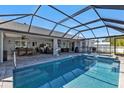 Relax in this beautiful screened-in pool with an attached spa and outdoor seating at 5198 White Ave, Port Charlotte, FL 33981