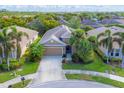 One-story home with tan exterior, two-car garage, and lush landscaping at 120 Cordana Ct, Venice, FL 34292