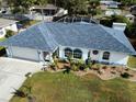 Single-story home with gray roof, white walls and blue accents at 1370 Kenmore St, Port Charlotte, FL 33952