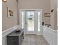 Bright entryway with decorative glass door and tile flooring at 182 Santarem Cir, Punta Gorda, FL 33983
