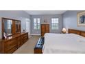Main bedroom with large bed and wood dresser at 25623 Heritage Lake Blvd. # 57, Punta Gorda, FL 33983