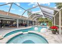 Relaxing pool and spa with covered lanai, outdoor seating, and lush landscaping at 28522 Coco Palm Dr, Punta Gorda, FL 33982