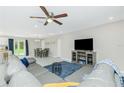 Open-concept living room featuring a modern ceiling fan and a view of the dining area at 2190 Taunt St, Port Charlotte, FL 33948