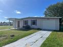 Ranch style home with a large yard, driveway, and mature trees at 2273 Ednor St, Port Charlotte, FL 33952