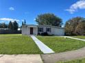 Ranch style home with a large yard, driveway, and mature trees at 2273 Ednor St, Port Charlotte, FL 33952