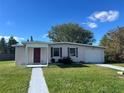 Ranch style home with a large yard, driveway, and mature trees at 2273 Ednor St, Port Charlotte, FL 33952
