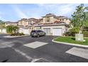 Exterior view of tan two-story condo with attached garage at 240 W End Dr # 212, Punta Gorda, FL 33950