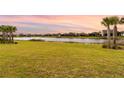 Landscaped backyard with pond and other houses visible at 42974 Parkside Ct, Punta Gorda, FL 33982