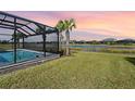 Screened pool with lake view and lush landscaping at 43015 Parkside Ct, Punta Gorda, FL 33982