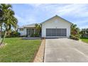House exterior with a metal roof, driveway, and lush lawn at 17458 Fuego Ln, Punta Gorda, FL 33955