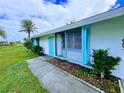 Side view of a single story home with teal accents and landscaping at 683 W Tarpon Nw Blvd, Port Charlotte, FL 33952