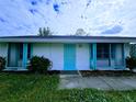 White single story home with teal accents and lush landscaping at 683 W Tarpon Nw Blvd, Port Charlotte, FL 33952