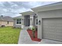 Well-maintained house featuring a two-car garage, neat landscaping, and a welcoming entrance at 14146 Baracoa Ln, Port Charlotte, FL 33981